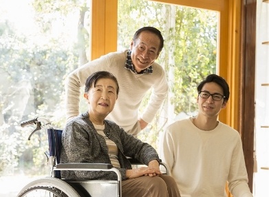 車椅子の人とその家族が微笑んでいる写真