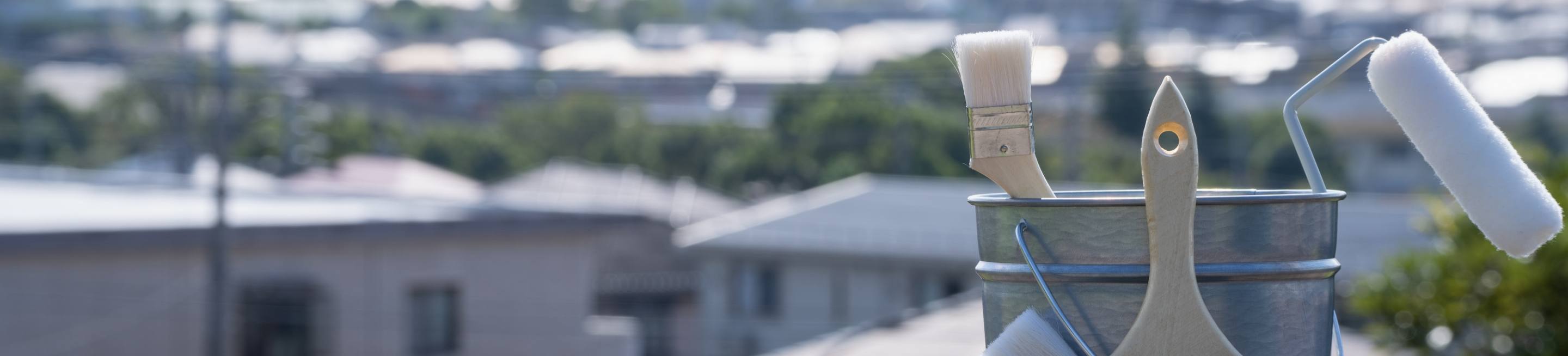 閑静な住宅街を背景にバケツやペンキなどが置いてある写真